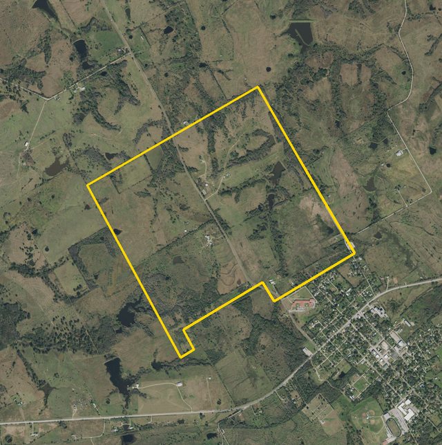 An aerial photograph from 2018 of pasture, tree lines and stock ponds, the Cazneau survey outlined in yellow, Blooming Grove at its lower right