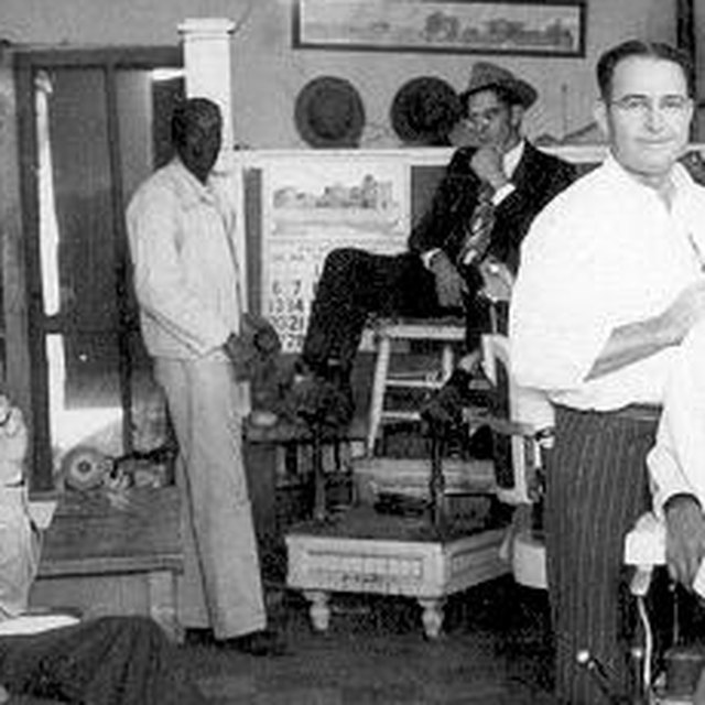 Detail: Kildee standing beside the shoe-shine stand, a customer seated on it, a calendar on the wall behind