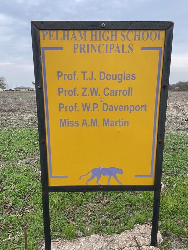A yellow signboard listing the principals of Pelham High School, beginning with Prof. T. J. Douglas